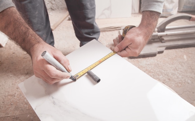 Tiler measures and cuts tile.