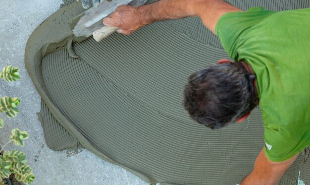 Tiler spreads glue with trowel for laying tiles