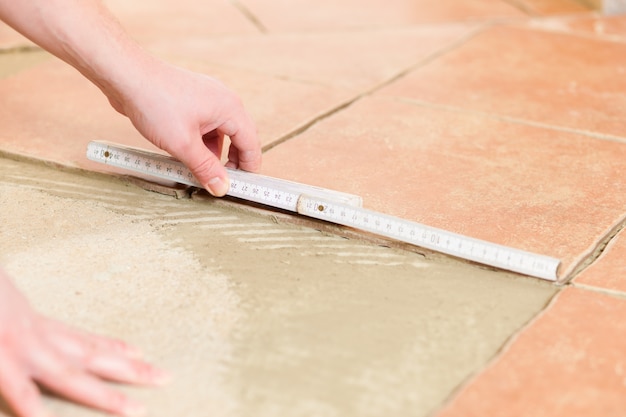 Tiler tiling tiles on the floor