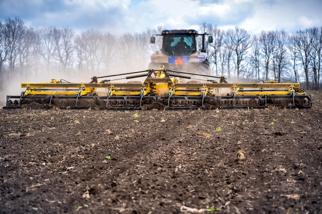 Tillage in the field with a tractor with a trailed machine.