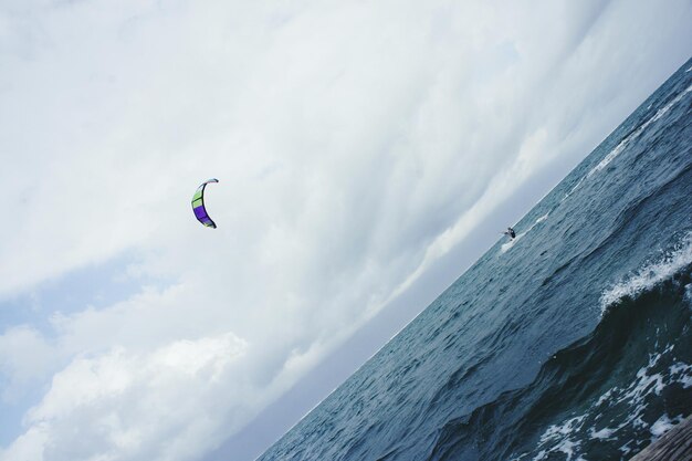 Фото Наклонное изображение человека, катающегося на кайтборде в море