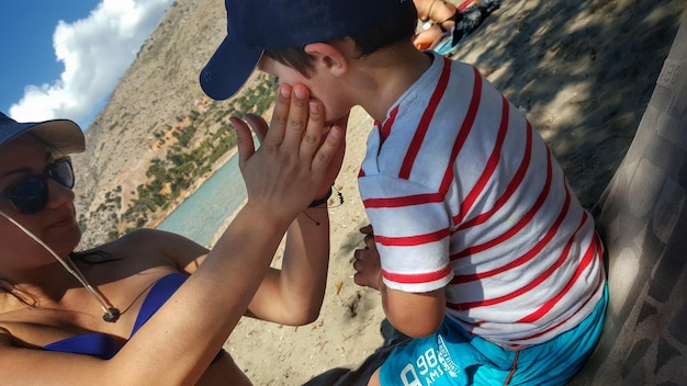 Foto foto inclinata di una madre che tocca il figlio sulla spiaggia