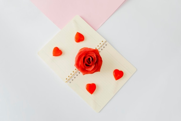 Tilted top view of candies and rose placed on book