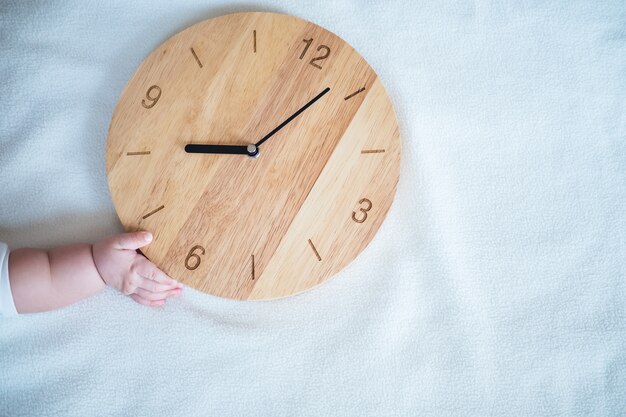 Time for Baby : baby hand  and wooden clock