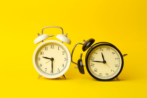 Time background concept. Vintage classic alarm clock on yellow empty background. Time management comcept