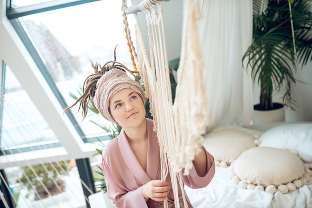 Time for hobby. Young woman spending time at home busy with her macrame