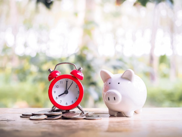 Time is money. red alarm on stack of coins with piggy bank save
money for prepare in the future