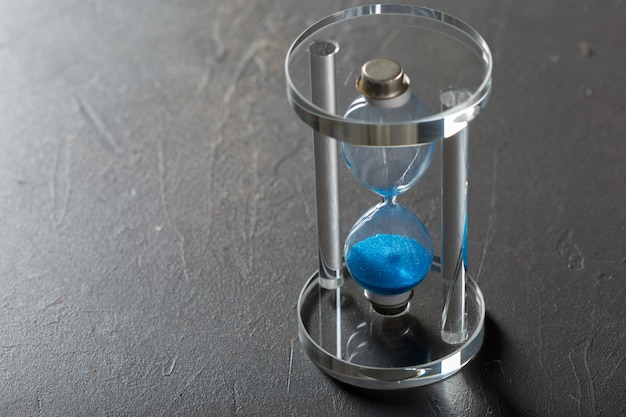 Time is passing. Blue hourglass close up