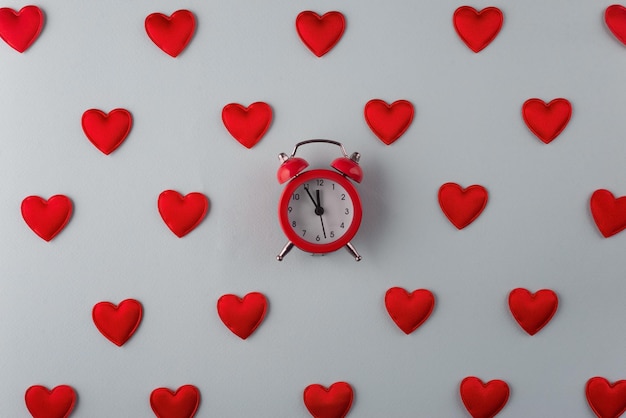 Photo time to love concept from small red hearts with clock on blue background