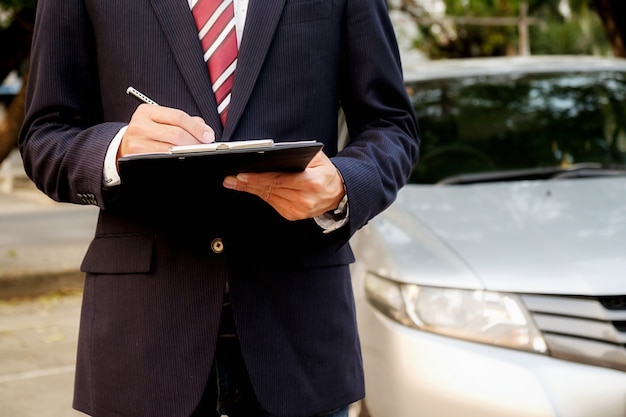 決定を下す時間。自信に満ちている若い実業家、彼のlabletで働いて、車に座っているときに電話で話す