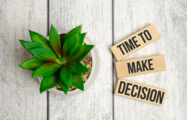 TIME to make decision words on wooden blocks and white wooden background