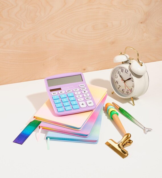 Time management concept Retro vintage alarm clock colorful notebooks to write down the necessary information pens colorful ruler Idea of office work