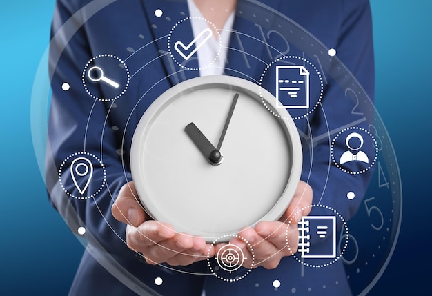 Time management concept Woman holding clock surrounded by icons closeup