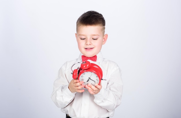 Time management Morning Party time Businessman Formal wear tuxedo kid Happy childhood little boy with alarm clock Time to relax happy child with retro clock in bow tie Quick chat at morning