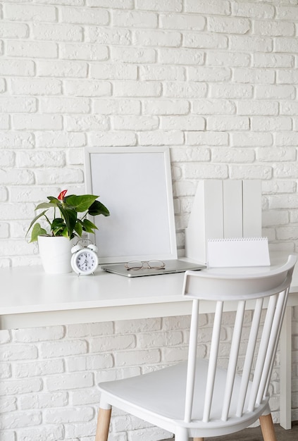 Time management, planning concept. front view of desk
arrangement with blank calendar for mock up, paper folders and
white frame in room interior. mock up design