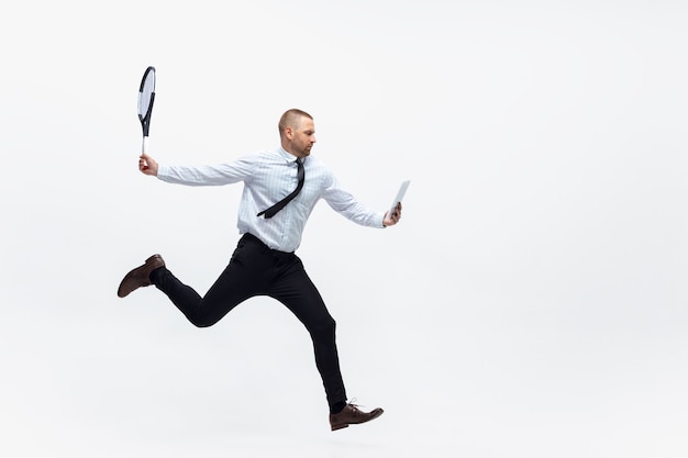 Photo time for movement man in office clothes plays tennis isolated on white studio background