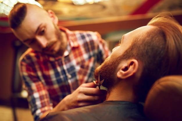 Time for a new hairdo. Handsome young bearded man came to the barber for a haircut. hipster style. the concept of fashion and beauty.