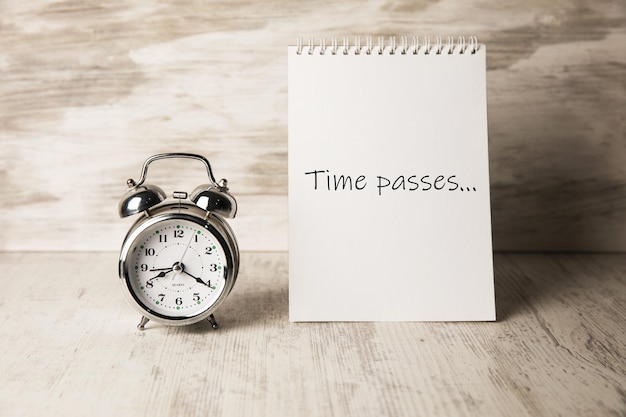 Time passes written on a notepad and a clock