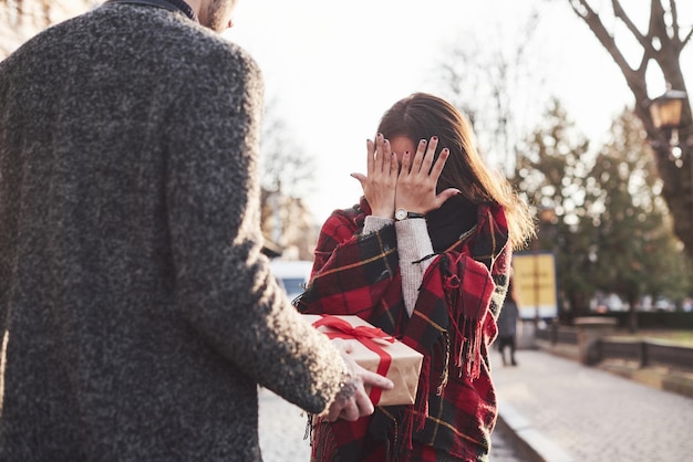 プレゼントの時間。ギフトボックスを持っています。彼女の白人のボーイフレンドとアジアの女の子。