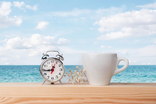 Time to relax looking at the sea A cup of coffee and a clock that marks the time to disconnect