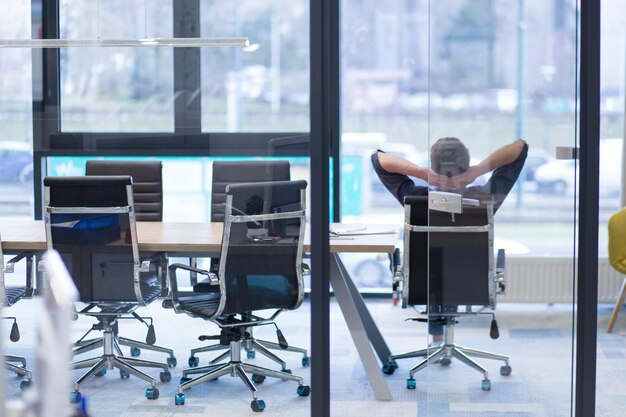 A time for relax. Young tired casual businessman relaxing at the desk in his office