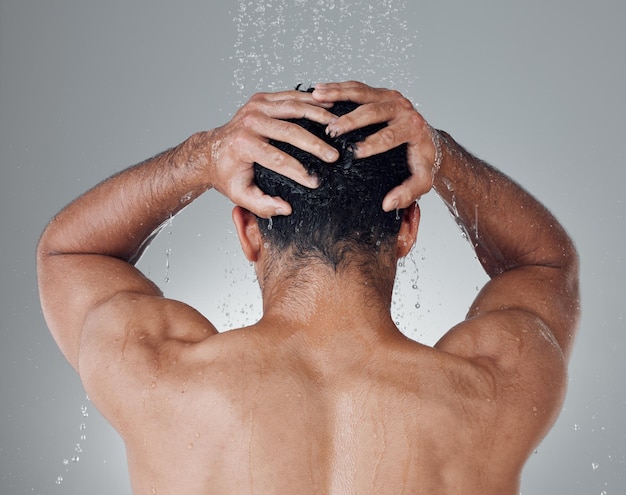 Time for a relaxing shower Shot of an unrecognizable man washing his hair in the shower against a grey background