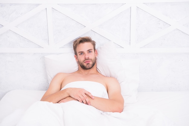 Foto tempo per riposare. concetto di erezione mattutina. addormentato e sveglio. rilassante in camera da letto. energia e stanchezza. uomo sexy a letto. piacevole risveglio. buon giorno. bel fine settimana pigro.