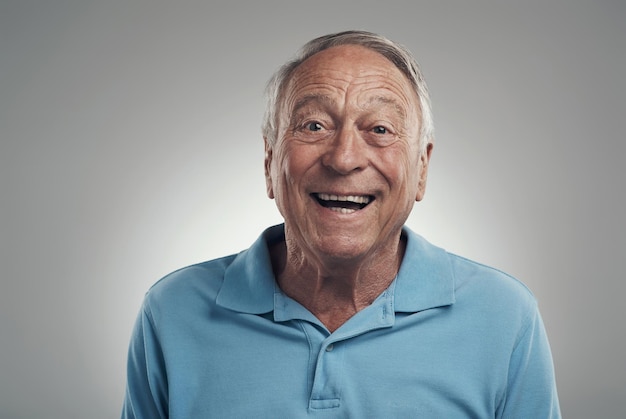 È ora di sorridere per un po' inquadratura di un uomo che sorride felicemente alla telecamera in uno studio su uno sfondo grigio