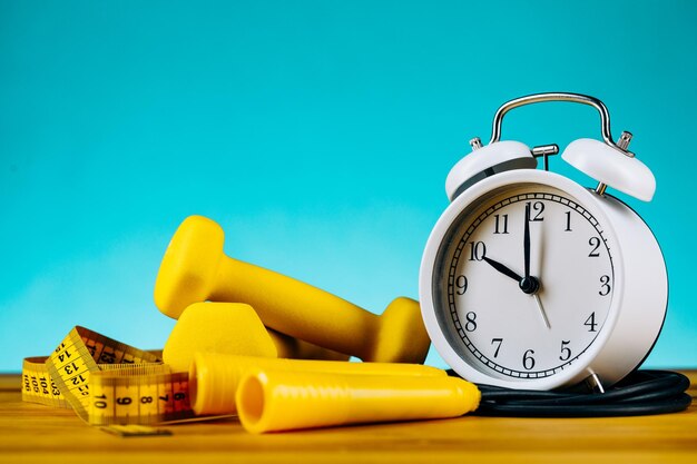 Time for workout clock and dumbbell with colorful blue background