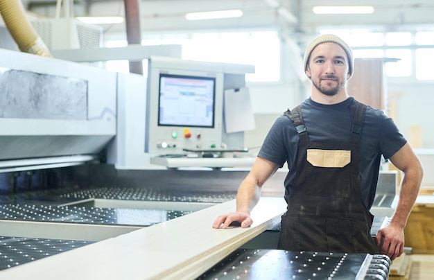 Timmerman aan het werk op de machine in de fabriek