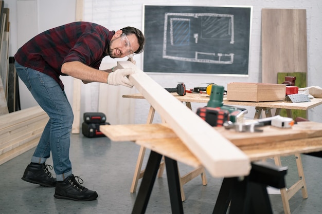 Timmerman die de kwaliteit van het hout controleert