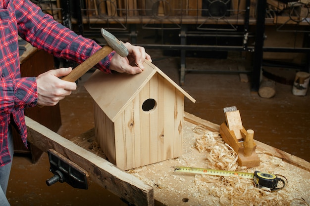 Timmerman die houten nestkast maakt