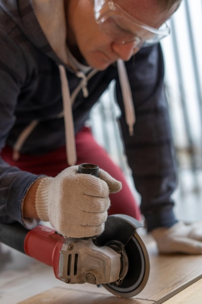 Foto timmerman die thuis aan de vloer werkt