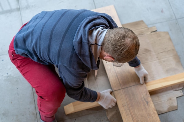 Foto timmerman die thuis hout snijdt