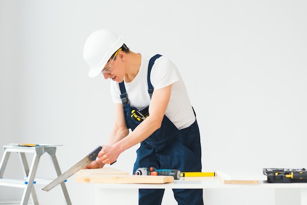 Timmerman die wit bord zagen tijdens het renoveren van het appartement