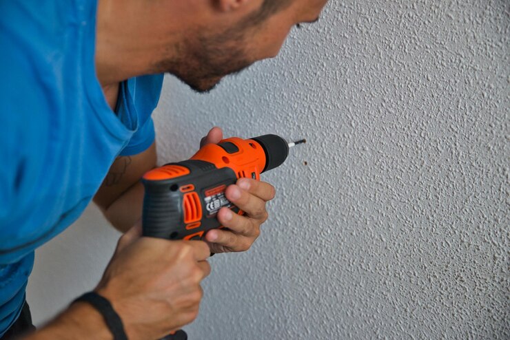 Timmerman die zorgvuldig werkt, man die een muur boort. Thuiswerken.