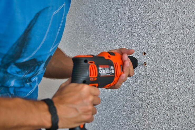 Timmerman die zorgvuldig werkt, man die een muur boort. Thuiswerken.