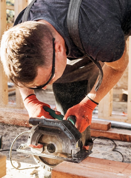 Timmerman man snijden een houten plank hoge mening