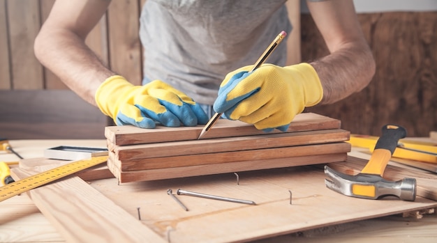 Timmerman merken op houten plank met een potlood.