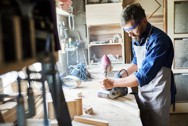 Timmerman Sanding Wood in Workshop