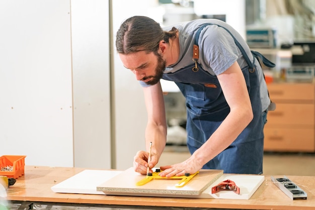 Timmerman werkt aan het houtbewerkingsbureau en meubels handgemaakt met hout