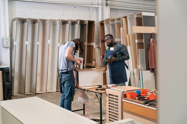 Timmerman werkt aan het houtbewerkingsbureau en meubels handgemaakt met hout