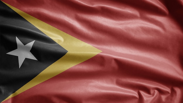 Timorese flag waving in the wind. East Timor template blowing, soft and smooth silk. Cloth fabric texture ensign background.