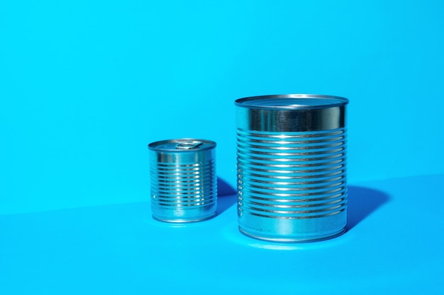 Tin can with food on blue surface