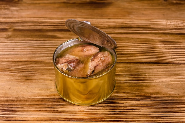 Tin can with sardine on wooden table