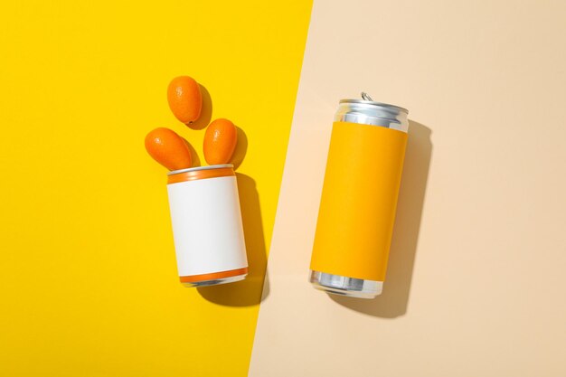 Tin cans and kumquats on yellow background top view