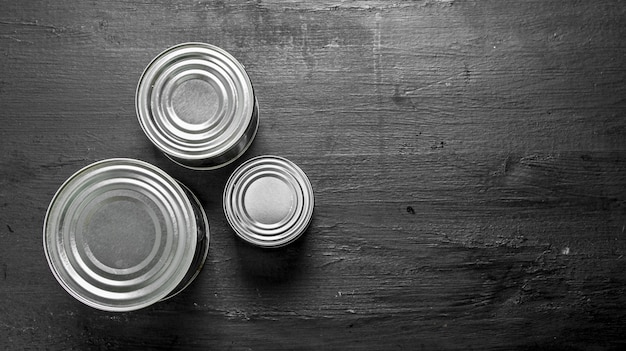 Tin cans with food on the black chalkboard