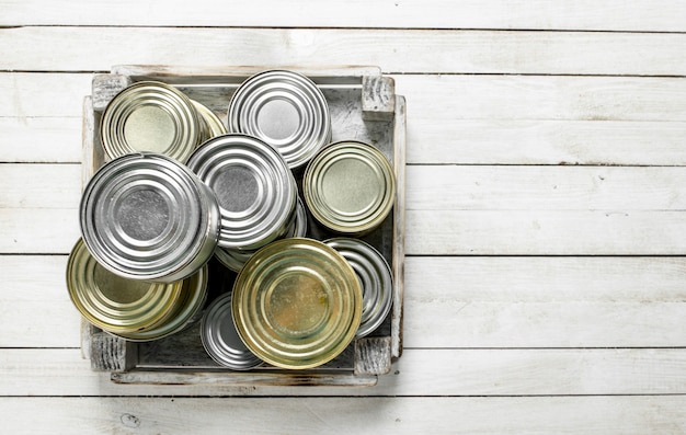 Photo tin cans with food in a box.