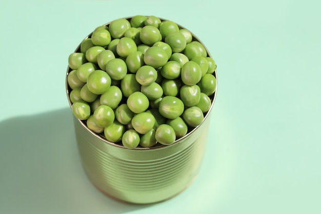 Tin jar, fully filled with fresh green peas with excess, close-up