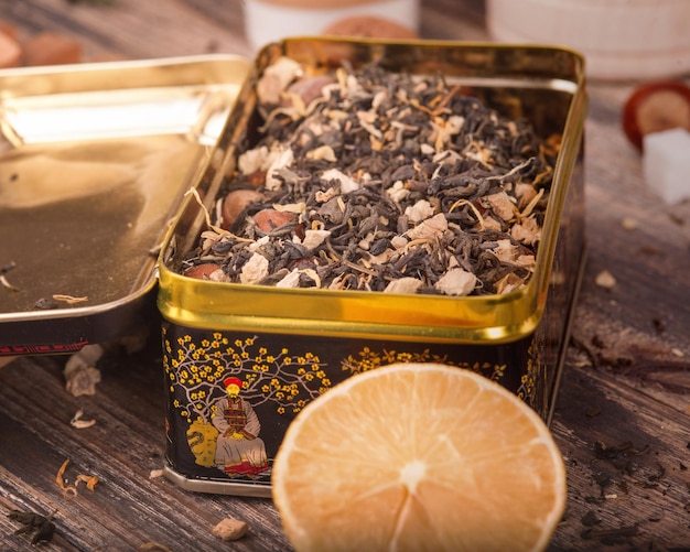 Photo a tin of lemon tea sits on a wooden table next to a lemon slice.